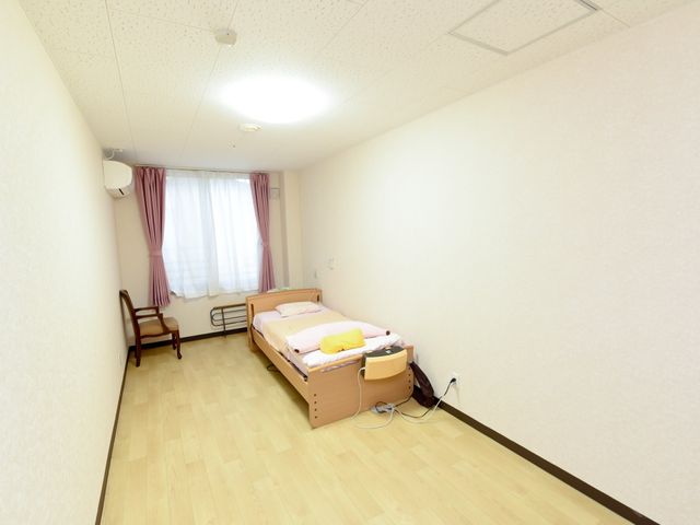 明るい個室の居室 居室 ゆったりとした個室で、落ち着いた色合いのカーテンが心地よい空間を演出しています。利用者のプライバシーを尊重した安心の設計です。