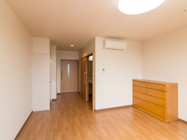 居室の明るい空間 居室 広々とした木目調の床が温かみを感じさせる部屋です。家具の配置もお好みに合わせて調整いただけます。