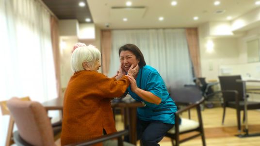 笑顔のスタッフと利用者の室内  