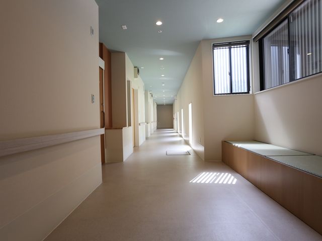 明るく広い廊下の風景 通路 ゆったりとした設計の廊下では、明るい日差しを感じながらゆとりある移動ができます。身体に優しい落ち着いた空間が広がっています。