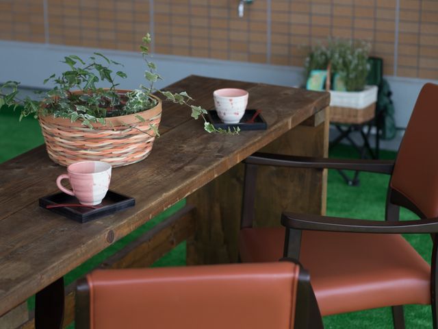 木のテーブルと植物の多目的室 ウッドデッキ ゆったりとした木のテーブル周りは、リラックスできる空間づくりに配慮されています。お茶をしながらくつろげる場所です。