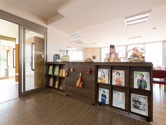 温かみのある受付コーナー 共有スペース 明るく開放的な空間の受付周辺です。立ち寄る人々が穏やかなひとときを過ごせるような雰囲気が感じられます。
