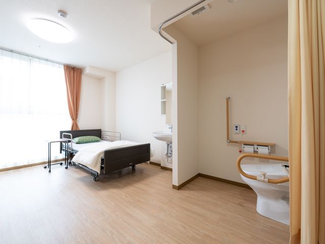 居室の明るい光景 居室 ゆとりのある居室で、光が差し込む窓と清潔な設備が整っています。安心して働ける環境をご提供します。