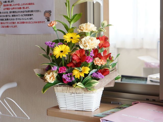 花と掲示物がある部屋 花 色鮮やかな花々が彩りを添える部屋の一角で、温かみのある雰囲気が感じられます。優しい環境での仕事に興味がある方にとって、快適な空間です。