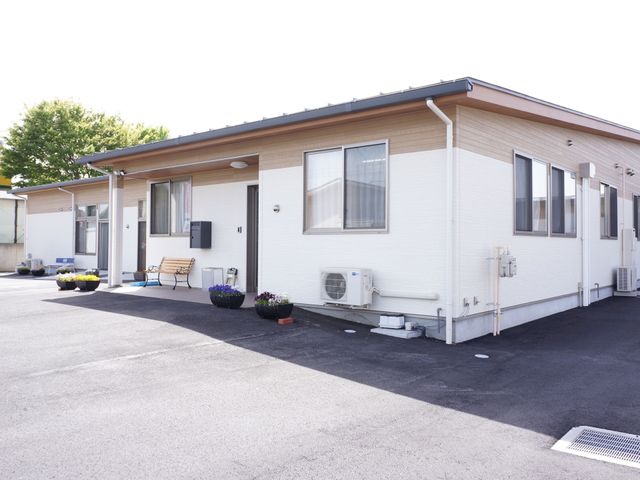居室のある建物外観 外観 清潔感のある外観で、ベンチが設けられ心地よい休憩スペースを提供しています。空調設備が整っており、一年を通して快適に過ごせる環境が整備されています。