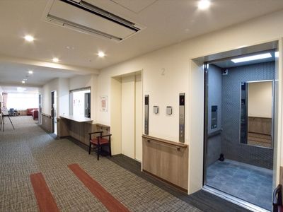 廊下にあるエレベーターと休憩スペース