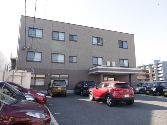 茶色の建物と駐車場の外観