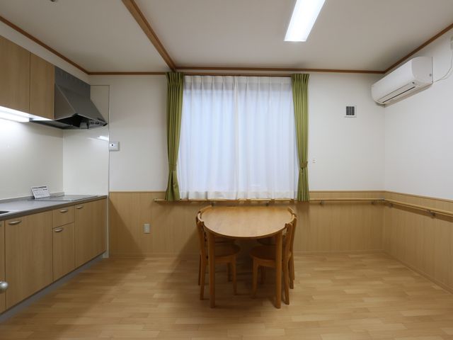居室のキッチンとテーブル 談話室 明るく清潔感のある居室が広がっており、日常生活に必要な設備が整っています。食事や趣味の時間を自分のペースで楽しむことができます。