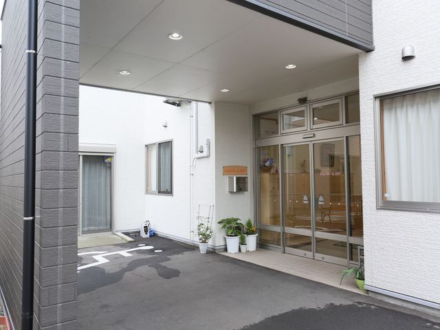 清潔感のあるエントランス 入口 ガラス張りのエントランスは採光を取り入れ、明るく開放的な雰囲気を醸し出しています。職員や来訪者の動線も考慮された設計です。