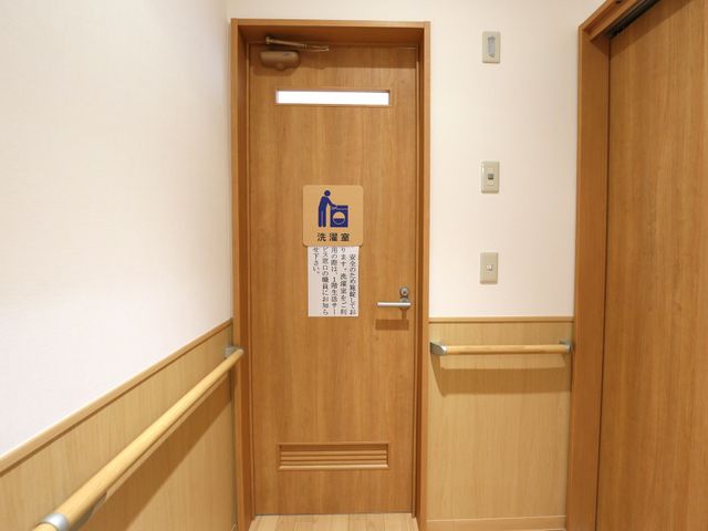 木目調の清潔なトイレ扉 洗濯室 清潔感のある木目調のトイレは、手すりがついており、安全に配慮されたつくりになっています。