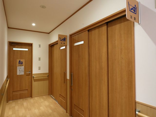 機能的な木製扉エリア 廊下 清潔感のある廊下は、落ち着いた木目調の扉が特長です。車椅子でも使いやすい配慮が見受けられます。