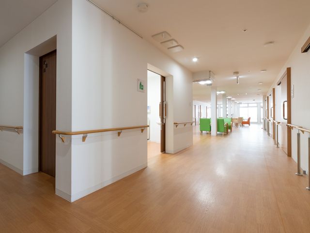 廊下の明るい通路 廊下 ゆったりとした廊下は木目調のフロアで温かみがあり、手すりが整備された安全な通路です。明るく開放的な空間でご入居者様の快適な移動を支えます。