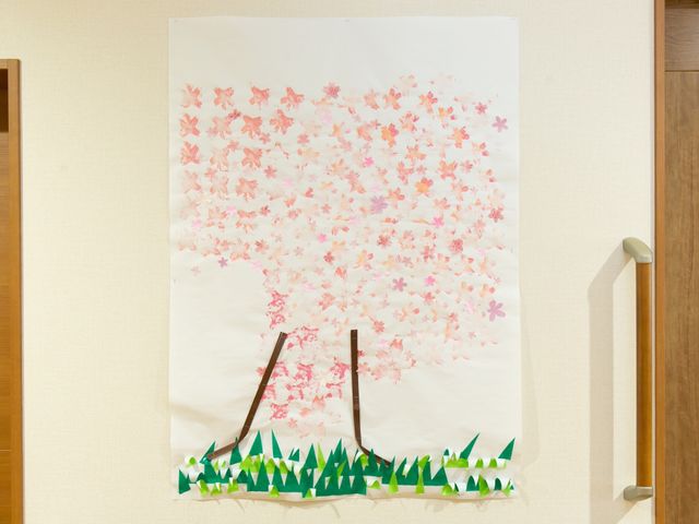 手作り桜の掲示物 作品 廊下に彩られた桜のモチーフが、明るく和やかな雰囲気を演出しています。ハンドメイドの装飾は、訪れる人の心を温かくします。