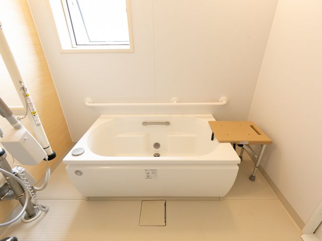 バリアフリー浴室設備 浴室 安全に配慮されたバリアフリー設計の浴室です。手すりや座面が整っており、利用者の快適な入浴を支えます。