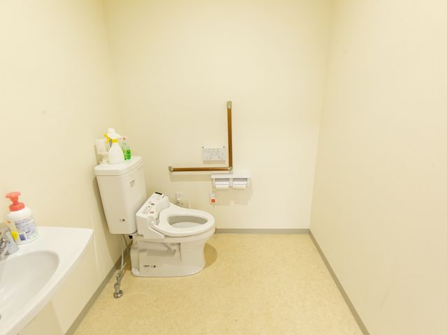 バリアフリートイレ設備 トイレ 手すり付きの安全に配慮されたトイレスペースです。利便性と快適さを提供し、ご利用者さまの日常生活をサポートしています。