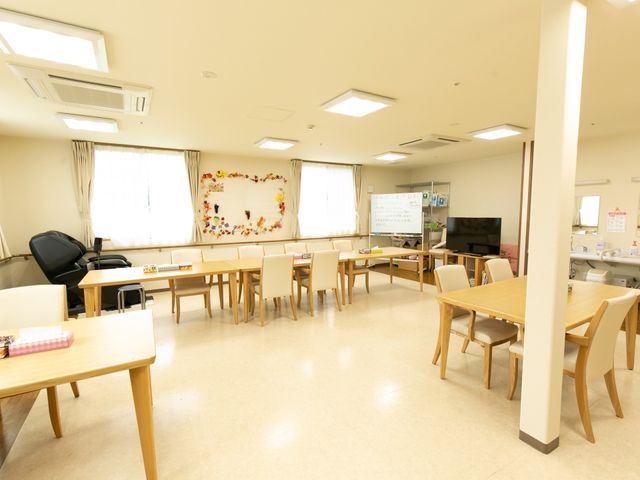 明るい共有スペース 共有スペース 天井の高い開放的なラウンジです。ゆったりとした椅子とテーブルが配置され、くつろぎながら交流がはかれる空間になっています。