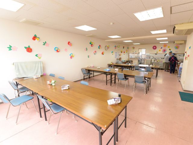 カラフルな装飾の食堂 共有スペース ゆとりのある食堂では色とりどりの装飾が施され、訪れる人々に明るい雰囲気を提供しています。利用者同士の交流も見受けられ、温かなコミュニティを感じさせる空間です。