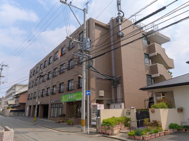 茶色の建物の外観 外観 地域に溶け込む落ち着いた色合いの建物です。このゆとりある空間で、新しい職場をお探しの方にご案内できます。