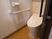 サムネイル 施設の写真 トイレの壁は白を採用、床はライトブラウンのフローリング敷になっている。壁には手すりとナースコールが設置されている。