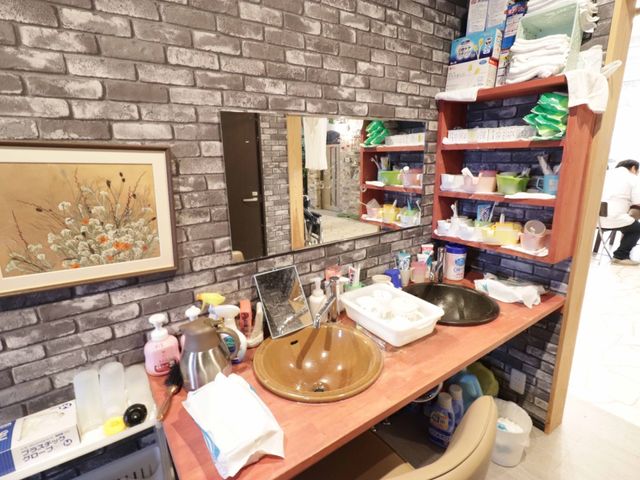 洗面台と備品棚 洗面台 整頓された洗面スペースです。働くときに必要な物品がきちんと整理されており、衛生管理にも配慮されています。