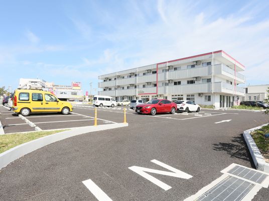 明るい駐車場と建物外観