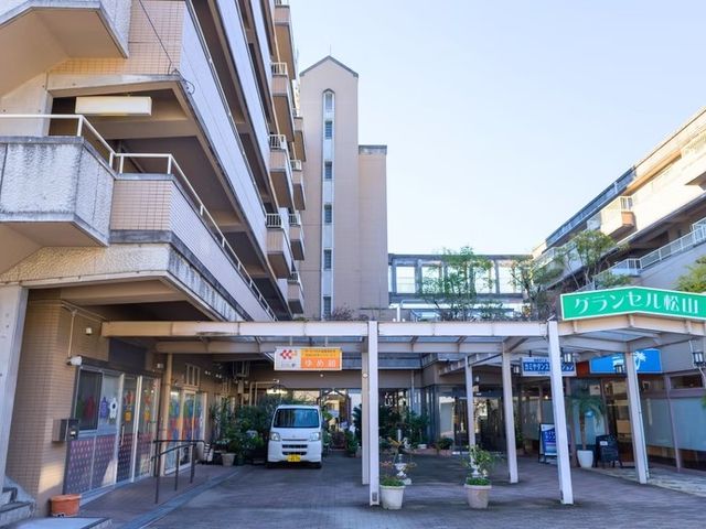 施設の外観 外観   建物の前に屋根付きの通路があり、車の乗り降りもしやすそうです。周囲に緑も見え、落ち着いた雰囲気です。