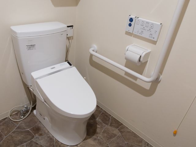 手すり付きの清潔なトイレ トイレ 安全で快適な使用を考慮した設計のトイレです。手すりは立ち座りをサポートし、安心してご利用いただけます。