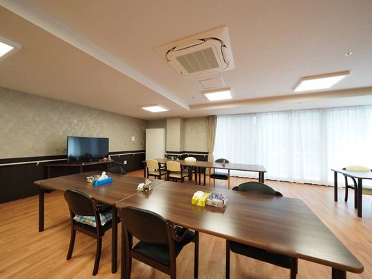 ダークブラウンの家具を設置した広いスペースである。天井に埋め込み式のエアコンがあり、快適に過ごすことができる。