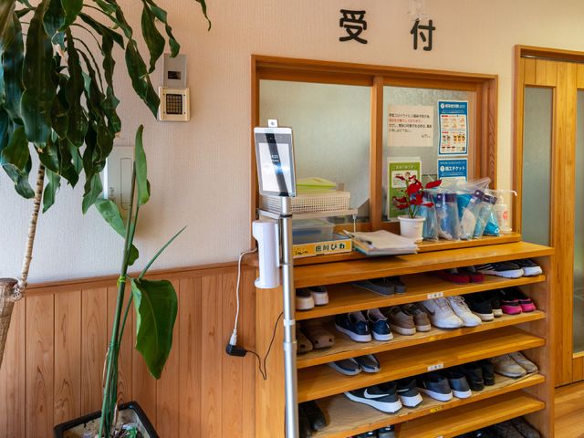 玄関の靴棚と案内板 玄関 玄関には清潔感のある靴棚が整然と配置され、来訪者を迎える案内板が設置されています。心地よい第一歩を踏み出せる空間です。