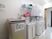 サムネイル 施設の写真 共通で利用できるランドリースペースである。洗濯機・乾燥機が並んでいる。壁には様々な注意書きが貼られている。