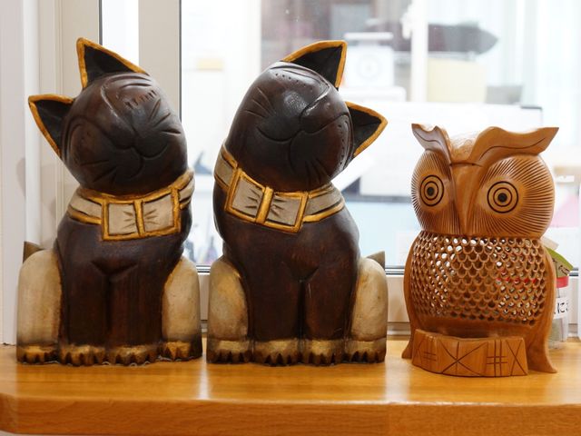彫刻された猫とフクロウ 受付 アクセントとして飾られた木彫りの猫とフクロウが、訪れる人の目を和ませています。明るく落ち着いた雰囲気のある待合スペースです。