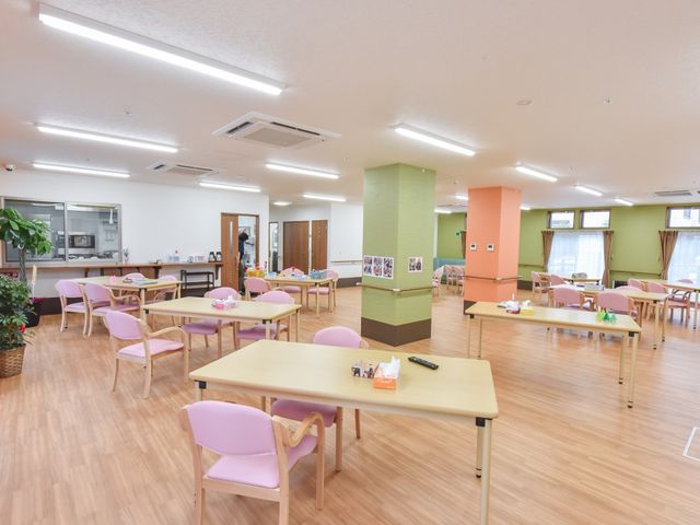 広々とした明るい食堂 共有スペース 木製のテーブルとピンクの椅子が並ぶ、ゆったりとした快適な食堂です。日々のコミュニケーションも楽しんでいただける暖かい空間が広がっています。