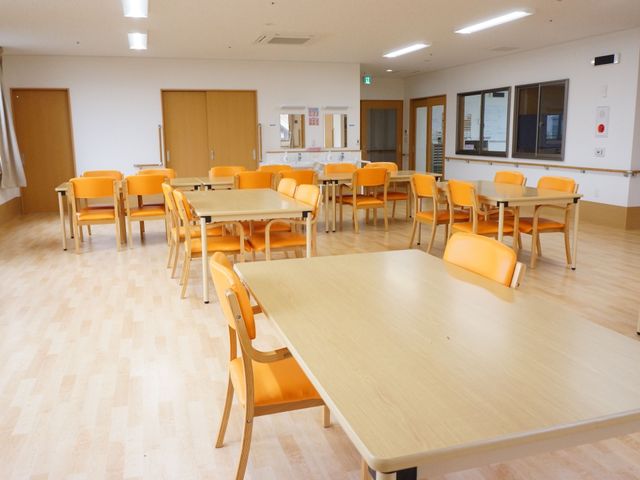 明るい共有ダイニングの様子 食堂 ゆったり配置されたテーブルと椅子が、共有ダイニングの温かい雰囲気を醸し出しています。広々とした空間で、日々の食事や交流が楽しめる環境です。