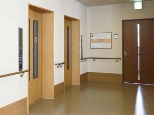エレベーターが２台並んで設置されている。周りの壁には手すりがついており、誰でも安全に使用することができる。