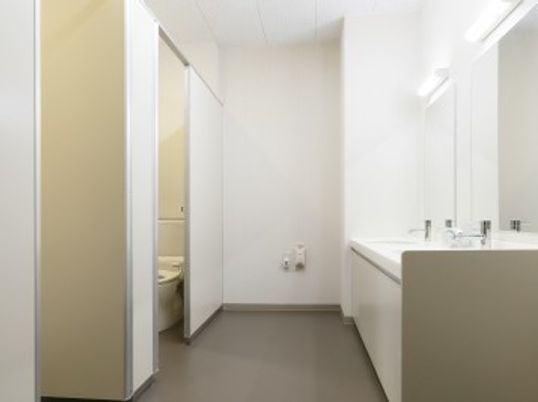 トイレには個室が２つ並んでおり、白い壁からは清潔感が感じられる。鏡付きの洗面台も、２台設置されている。