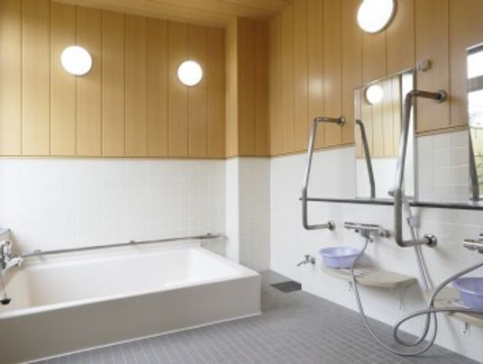 浴槽の壁、洗い場に手すりが設置されており、安全に入浴することができる。浴室の上部は木の壁となっており、温かみある。