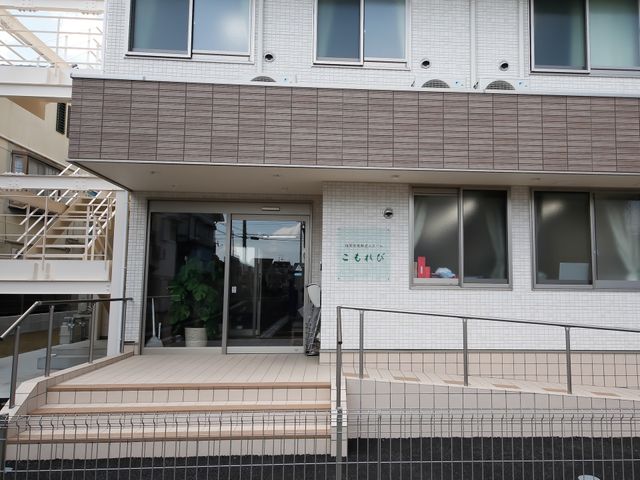 モダンな建物のエントランス 外観 モダンで清潔感のあるエントランスです。スロープが設置されており、バリアフリーへの配慮が見られます。