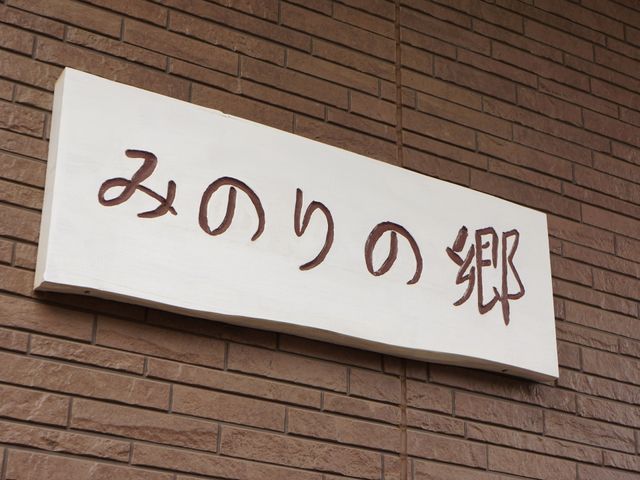 茶色の文字の看板 表札 心温まる文字が印象的なエントランスの看板。訪れる方を優しい気持ちで迎え入れます。