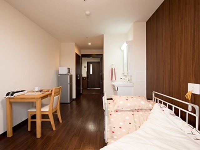 快適な個室の居室 居室 シンプルで清潔感のある居室は、快適な個人空間を提供しています。ベッド周りには十分なスペースが確保されており、生活しやすい環境が整っています。