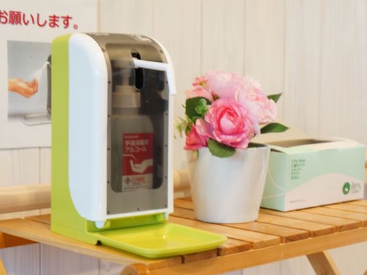 手指消毒器と花のある風景