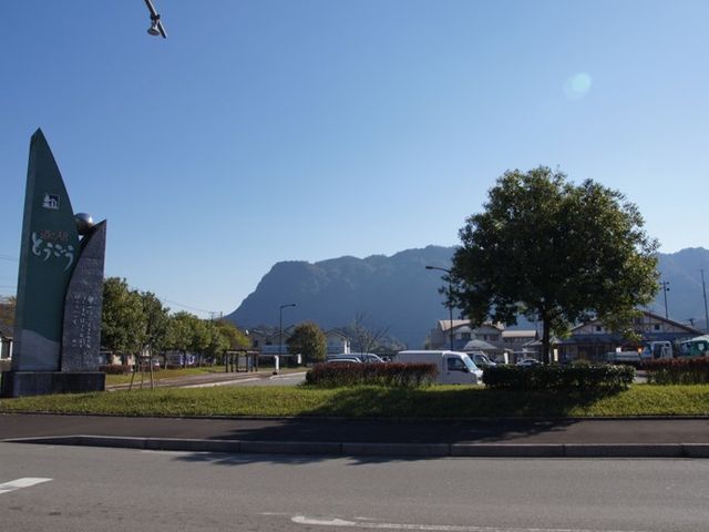 看板と山並みの風景 周辺環境 山々を背にした清々しい場所に位置する明るい印象の看板が目を引きます。周辺の自然環境と調和した立地で、新しい仕事をスタートしてみませんか。