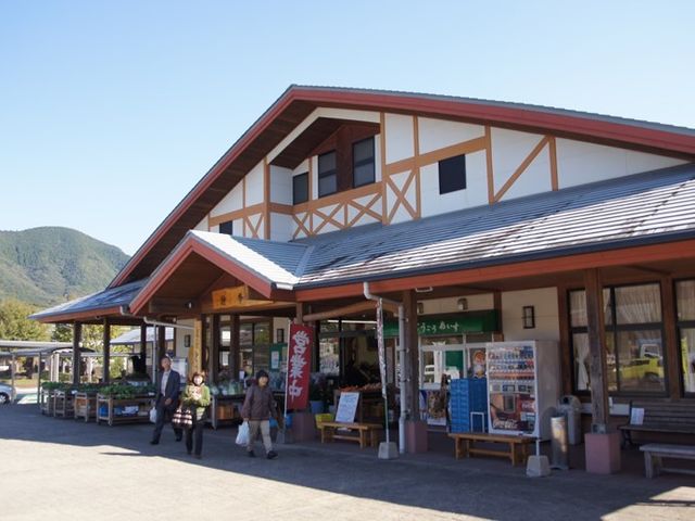 山々を背にした快適な施設 周辺環境 自然に囲まれた明るく開放的な施設外観で、訪れる方々が和やかに歩く様子が伺えます。新しい仕事場として、快適な環境がお待ちしております。