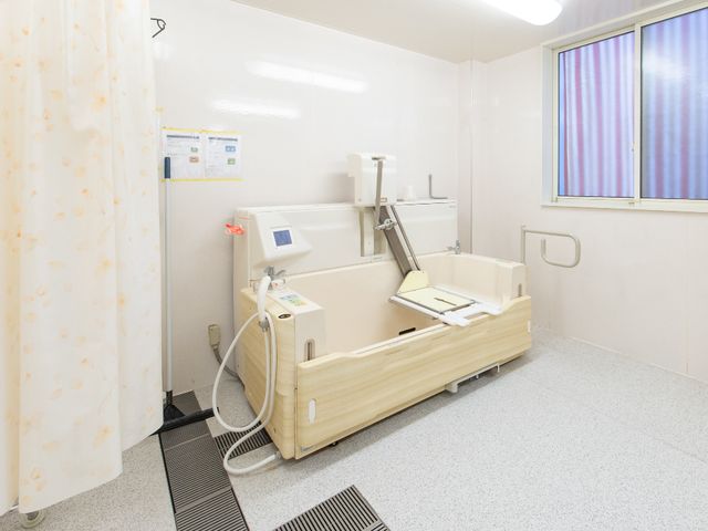 バリアフリー設計の浴室 介護浴室 安全かつ快適な入浴体験をサポートする、機能性と安心感のあふれる浴室です。明るい光が窓から差し込む、清潔な空間が広がっています。