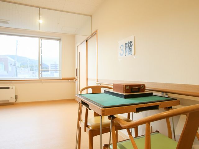 明るい個室の一角 サンルーム 窓から自然光が差し込むきれいな空間です。チェアと机が設置され、くつろぎや自分の時間を大切にできる環境が整っています。