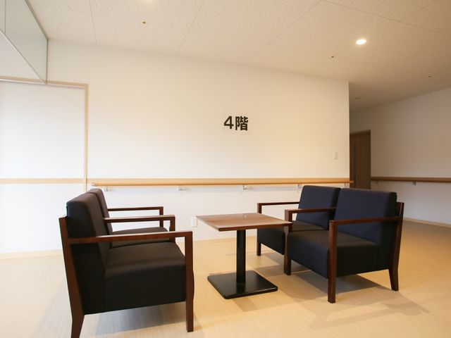 待合スペースの風景 サンルーム シンプルで清潔感のある休憩室は、落ち着きのある空間を提供しています。日々のコミュニケーションに最適な場所です。