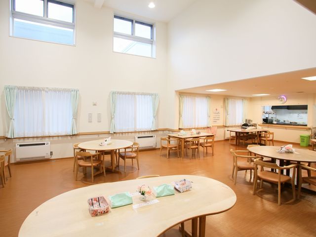 共用ダイニング空間 食堂 天井が高く、自然光がたっぷり入るダイニングで、利用者同士のコミュニケーションが楽しめます。円卓もあり、アットホームな雰囲気の中で食事をお楽しみいただける設計です。