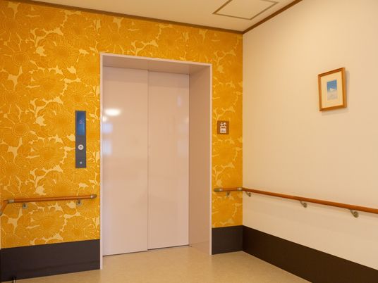 黄色い花柄の壁紙のエレベーター