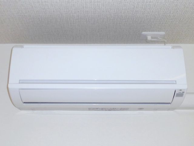 白い壁に取り付けられたエアコン エアコン 最新のエアコンが整備され、快適な環境が維持されています。清潔感のあふれる空間での仕事が期待できます。