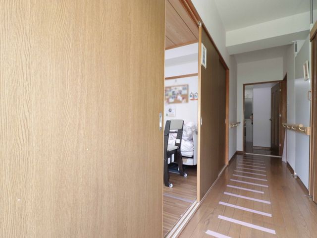 廊下から居室への視点 廊下 広々とした廊下が居室へとつながっており、手すりも完備されています。作業に集中されている方がいらっしゃる安心感のある環境です。