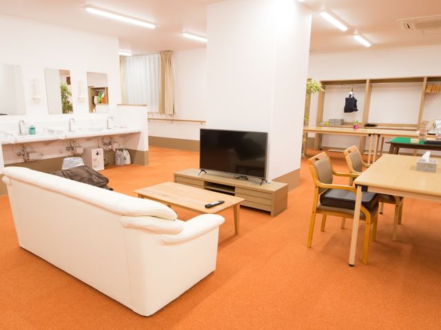 快適な共有リビング空間 食堂 広くて明るいリビングでは、快適なソファや大型テレビでのんびりとくつろぐことができ、日々の憩いの場を提供しています。